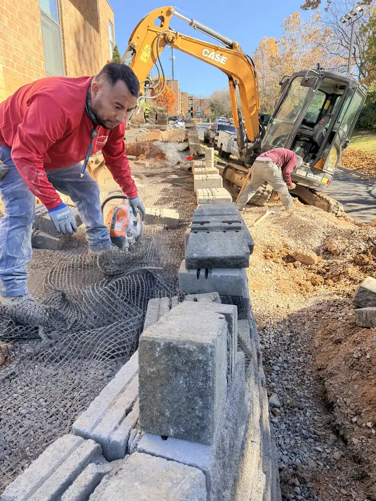 Crew setting block and mesh for a retaining wall in Knoxville, Tennessee