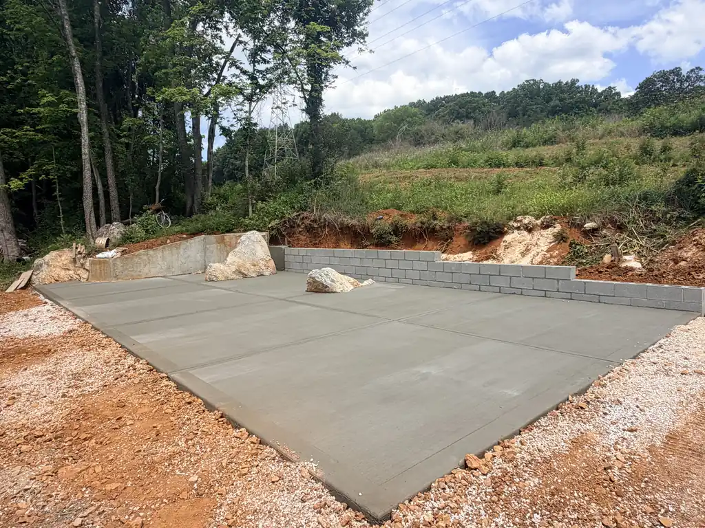 Finished block retaining wall around a new concrete pad in Knoxville, Tennessee
